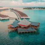 Aerial view of Soneva Fushi island resort, Maldives — turquoise lagoon and overwater villas