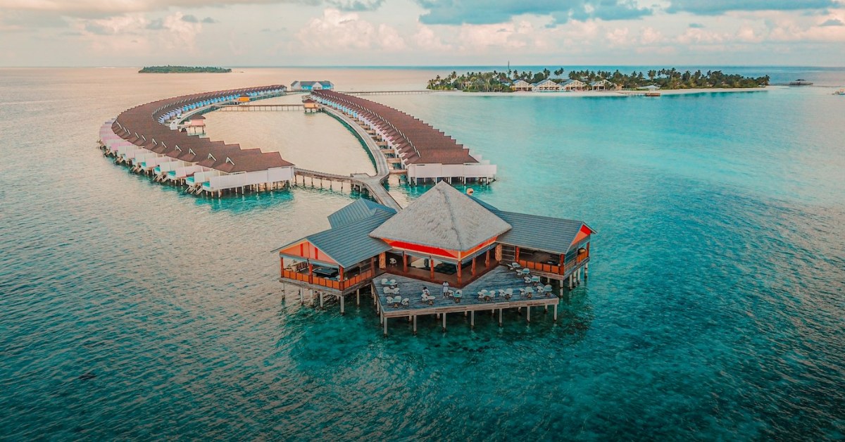 Aerial view of Soneva Fushi island resort, Maldives — turquoise lagoon and overwater villas