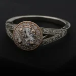 A brilliant-cut diamond halo ring on a dark surface, illustrative of investment-grade diamond jewellery.