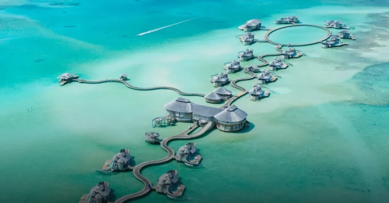 Aerial view of overwater villas in a Maldives atoll — staying at The Ritz-Carlton Maldives with Bitcoin
